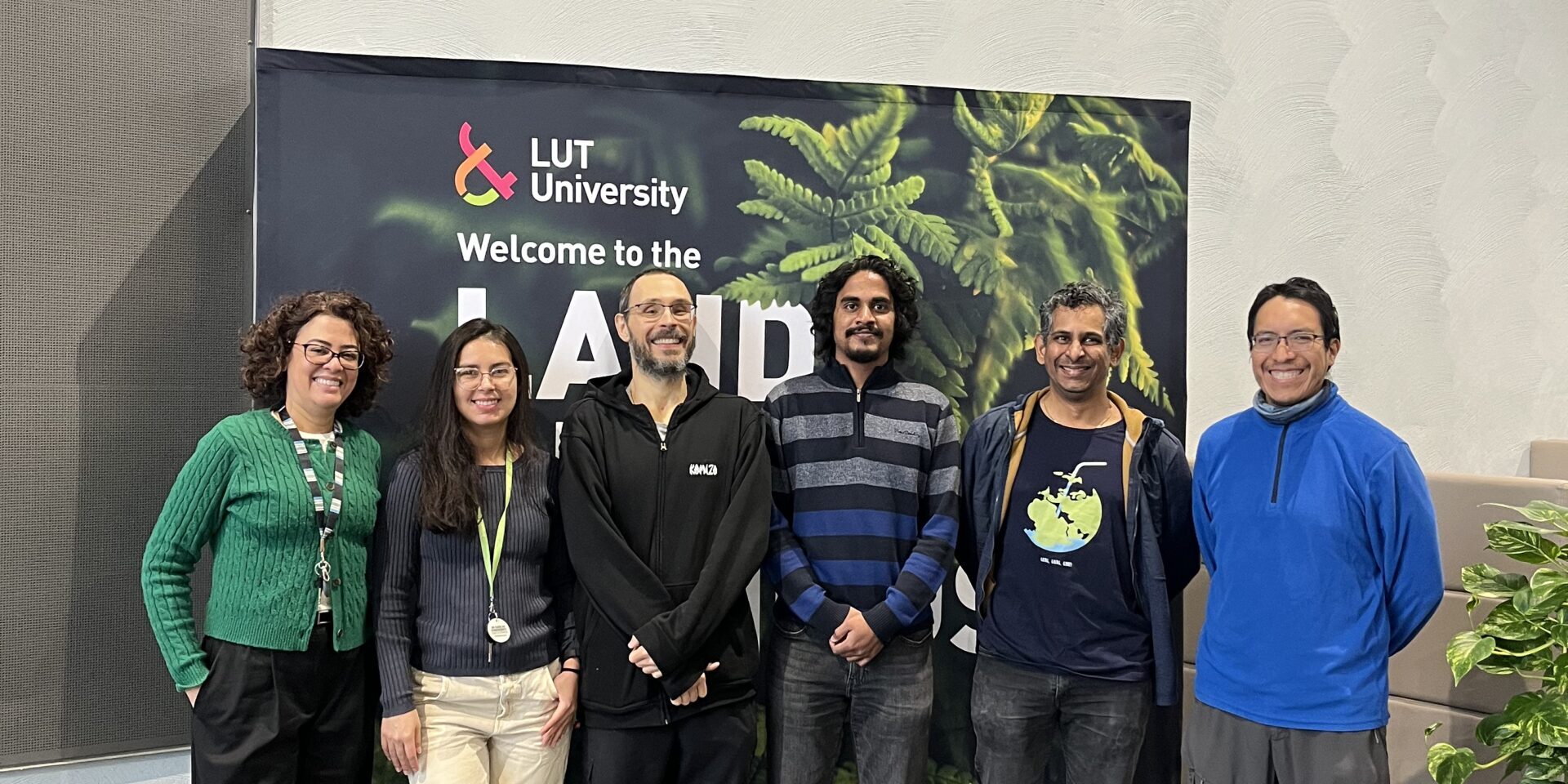 With_LUT_people Group of people in front of an LUT University banner smiling.
