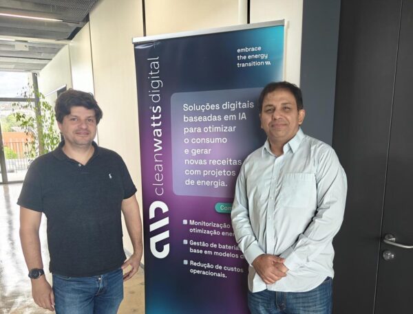 Dr. Mehar Ullah posing for photo with colleague in front of Cleanwatts Digital pull up banner