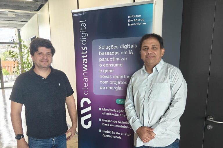 Dr. Mehar Ullah posing for photo with colleague in front of Cleanwatts Digital pull up banner