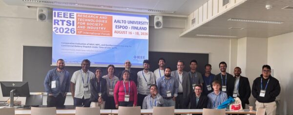 Coalesce partners posing for photo in front of presentation at the IEEE RTSI Conference 2026 in Finland