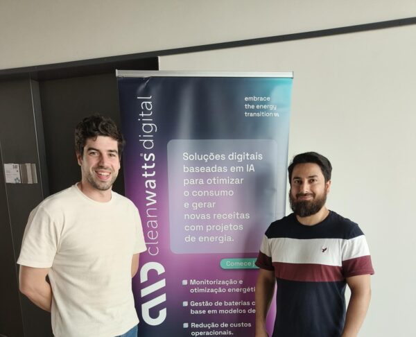 Majid with colleague posing in front of Cleanwatts Digital sign.