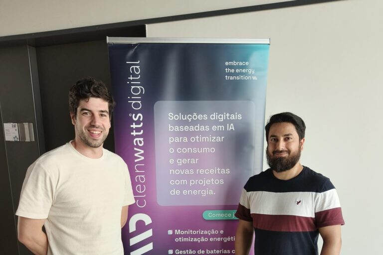 Majid with colleague posing in front of Cleanwatts Digital sign.